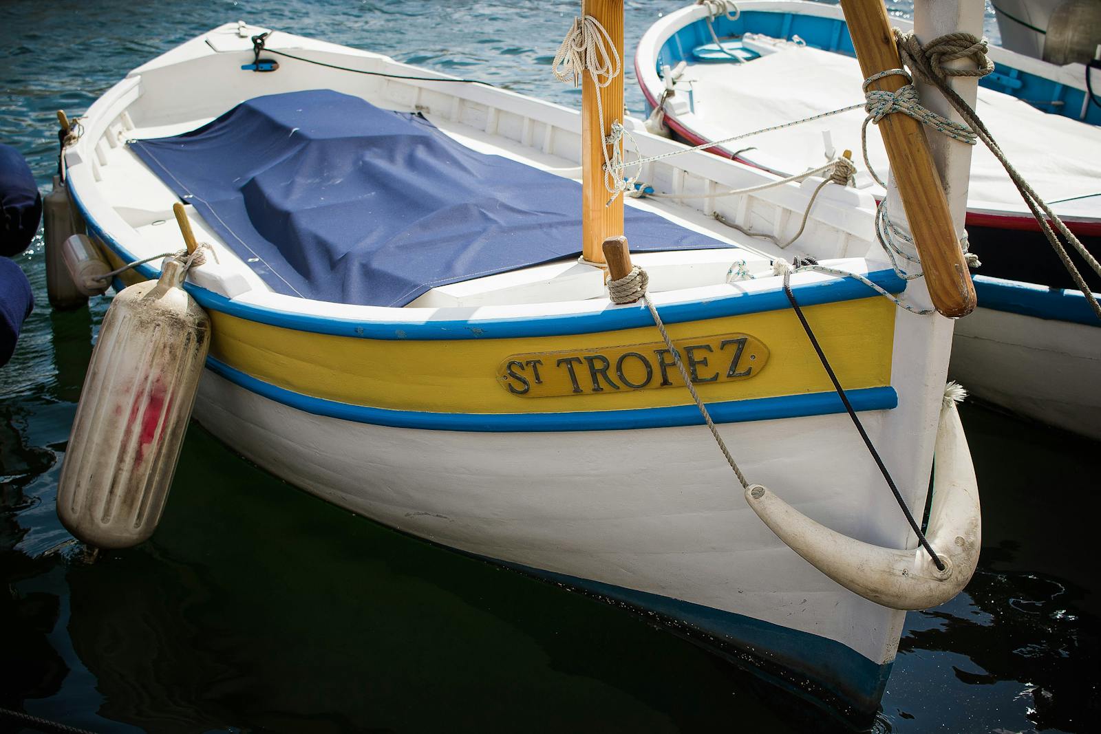 Barque traditionnelle en bois aux couleurs jaune et bleu, amarrée dans le port du golfe de Saint-Tropez. Une des quatre embarcations qui approvisionnent Chez Camille en poisson sauvage.