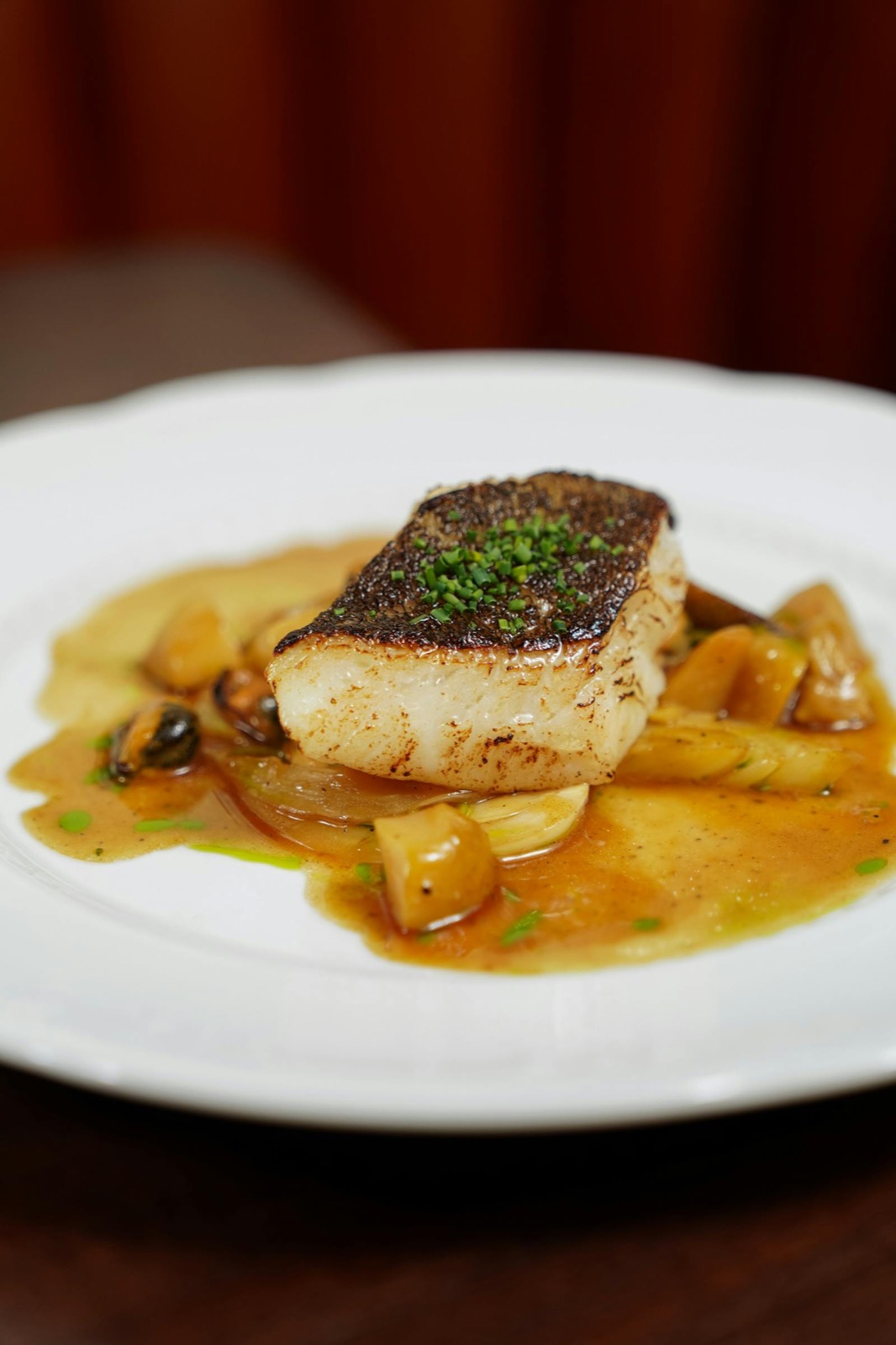 Sole meunière dressée à l'assiette, sauce beurre noisette légère et garniture de légumes printaniers.